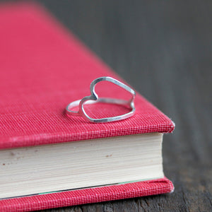 Understated and simple handmade heart ring on book jewelry display